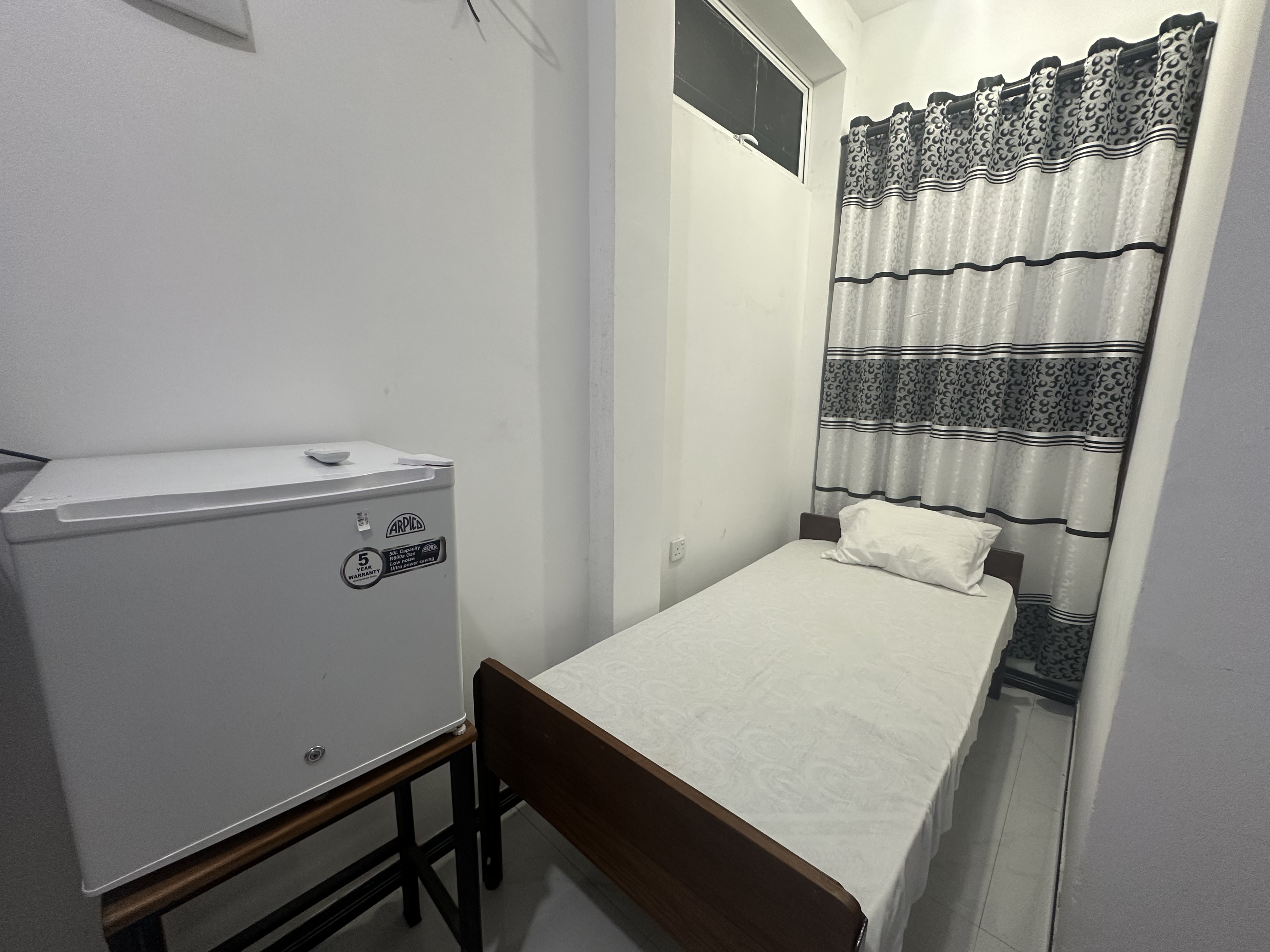 Clean Single Room with a comfortable bed at White House Galaha