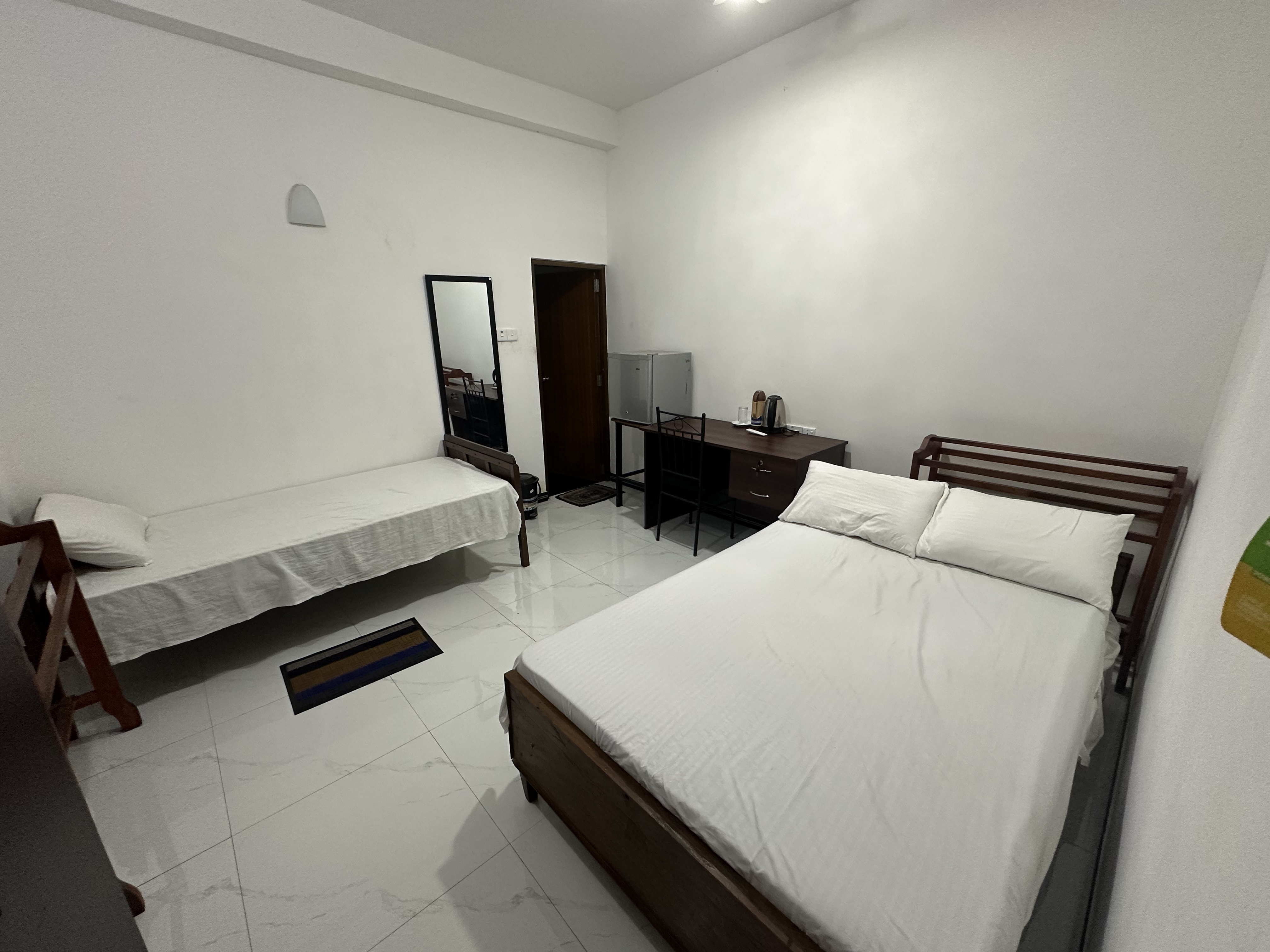 Spacious twin layout with two beds, desk and mirror in the Two Double Rooms